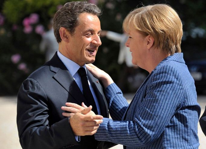 Francouzský prezident Nicolas Sarkozy při vítání německé kancléřky Angely Merkelové před Elysejským palácem v Paříži. 16. srpna 2011.