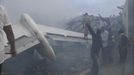 A still image taken from video shows emergency workers and volunteers around the wreckage of the tail of a plane that crashed in Lagos June 3, 2012. The passenger plane carrying nearly 150 people crashed into a densely populated part of Lagos on Sunday, in what looked like a major disaster in Nigeria's commercial hub. There was no early word from airline or civil aviation authority officials in the West African country on casualties. REUTERS/Stringer (NIGERIA - Tags: DISASTER TRANSPORT) Published: Čer. 3, 2012, 8:06 odp.