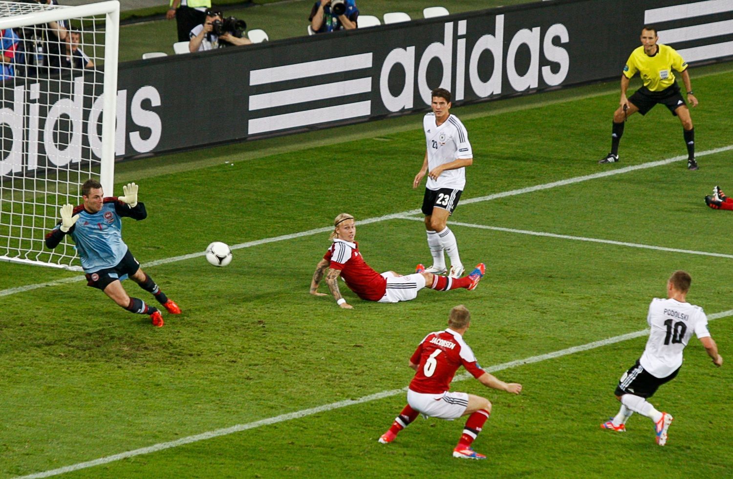 Německý fotbalista Lukas Podolski skóruje za záda Dána Stephana Andersena v utkání skupiny B na Euru 2012