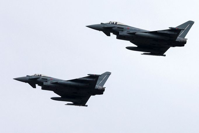 Vojenské stíhačky Eurofighter Typhoon přelétají nad nově zrekonstruovanou leteckou základnou NATO.