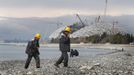 Construction workers return from their lunch break at the seafront next to the Olympic stadium for the Sochi 2014 Winter Olympics in Adler, near Sochi February 18, 2013. Although many complexes and venues in the Black Sea resort of Sochi mostly resemble building sites that are still under construction, there is nothing to suggest any concern over readiness. Construction will be completed by August 2013 according to organizers. The Sochi 2014 Winter Olympics opens on February 7, 2014. REUTERS/Kai Pfaffenbach (RUSSIA - Tags: BUSINESS CONSTRUCTION ENVIRONMENT SPORT OLYMPICS) Published: Úno. 18, 2013, 6:33 odp.