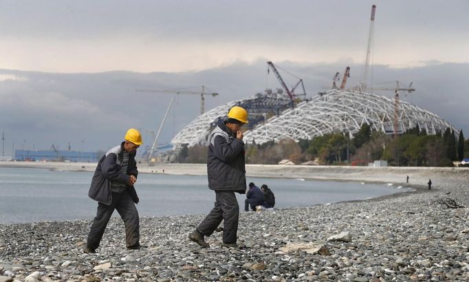 Construction workers return from their lunch break at the seafront next to the Olympic stadium for the Sochi 2014 Winter Olympics in Adler, near Sochi February 18, 2013. Although many complexes and venues in the Black Sea resort of Sochi mostly resemble building sites that are still under construction, there is nothing to suggest any concern over readiness. Construction will be completed by August 2013 according to organizers. The Sochi 2014 Winter Olympics opens on February 7, 2014. REUTERS/Kai Pfaffenbach (RUSSIA - Tags: BUSINESS CONSTRUCTION ENVIRONMENT SPORT OLYMPICS) Published: Úno. 18, 2013, 6:33 odp.