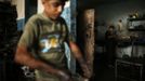 Palestinian Abed al-Majeed Reheem (R), 18, works in a car repair garage in Gaza City May 30, 2013. Reheem left school to work as an apprentice in the garage so that he could support his family's income. Apprentice mechanics earn around $100 per month, garage owners said. REUTERS/Mohammed Salem (GAZA - Tags: TRANSPORT SOCIETY EMPLOYMENT) Published: Kvě. 30, 2013, 12:54 odp.