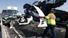 A rescue worker carries a piece of the wreckage of one of the 100 vehicles involved in multiple collisions, which took place in dense fog during the morning rush hour, on the Sheppey Bridge in Kent, east of London, September 5, 2013. Eight people were seriously injured and dozens hurt in the multiple crashes.