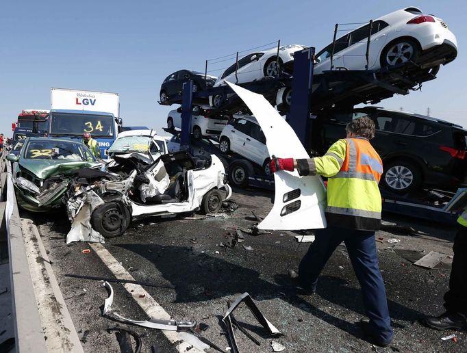 A rescue worker carries a piece of the wreckage of one of the 100 vehicles involved in multiple collisions, which took place in dense fog during the morning rush hour, on the Sheppey Bridge in Kent, east of London, September 5, 2013. Eight people were seriously injured and dozens hurt in the multiple crashes.