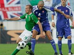 Severoirský fotbalista Warren Feeney (vlevo) bojuje o míč se Slovákem Martinem Petrášem (uprostřed). Souboj sleduje Martin Škrtel.