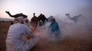 Camel herders sit around a bonfire to warm themselves as they wait for customers at Pushkar Fair in the desert Indian state of Rajasthan November 22, 2012. Many international and domestic tourists throng to Pushkar to witness one of the most colourful and popular fairs in India. Thousands of animals, mainly camels, are brought to the fair to be sold and traded. REUTERS/Danish Siddiqui (INDIA - Tags: ANIMALS SOCIETY) Published: Lis. 22, 2012, 5:29 odp.