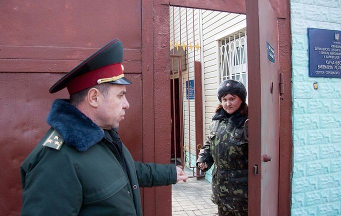 Staff talks near a gate to Kachanivska penitentiary colony for women in Kharkiv on March 16, 2012, where former Ukrainian Prime Minister and opposition leader Yulia Tymoshenko is currently held.