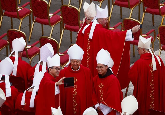 Kardinálové si před pořizují selfie.