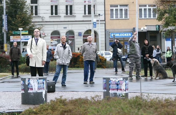 Ustrnulí. Lidé sledují vrtulník nad Žižkovem z náměstí Jiřího z Poděbrad.