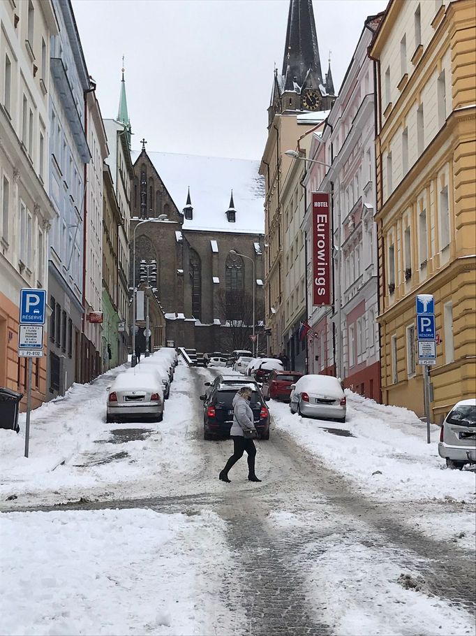 Naopak řidičům zasněžená dlážděná vozovka spíš přidělává starosti, kola se jim při cestě do kopce často protáčí.