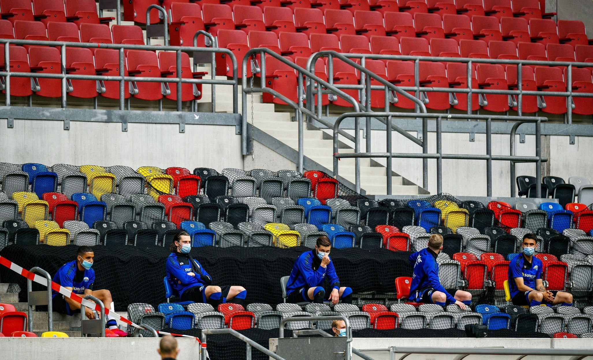 Náhradníci Fortuny Düsseldorf sedí v hledišti během zápasu s Paderbornem