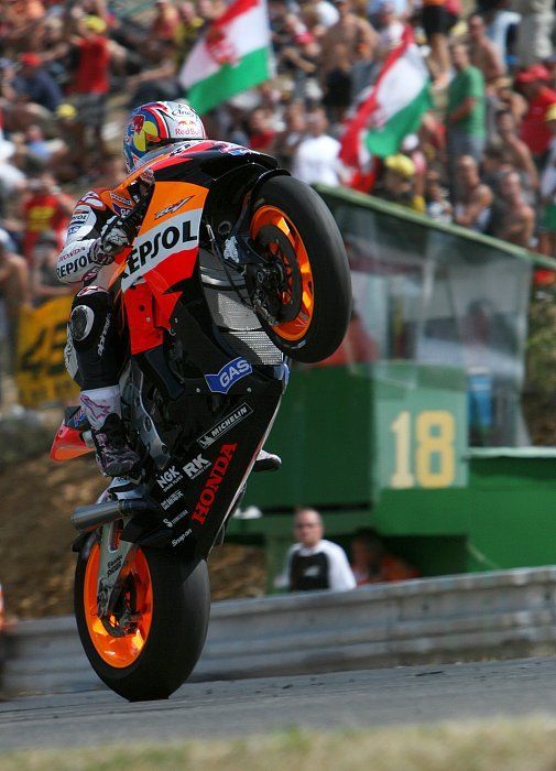 Nicky Hayden (#1, Honda) zdraví fanoušky ve stoupání do cílové rovinky po té, co zajel v kvalifikaci na nedělní 2. nejrychlejší čas (1:57.164).