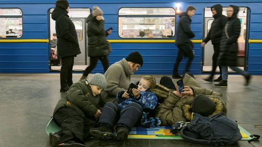Lidé se ukrývají ve stanici metra během masivních ruských raketových útoků v ukrajinském Kyjevě.