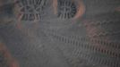 Footprint and bike tracks are seen in the dust at sunrise during the Burning Man 2012 "Fertility 2.0" arts and music festival in the Black Rock Desert of Nevada, August 29, 2012. More than 60,000 people from all over the world have gathered at the sold out festival, which is celebrating its 26th year, to spend a week in the remote desert cut off from much of the outside world to experience art, music and the unique community that develops.