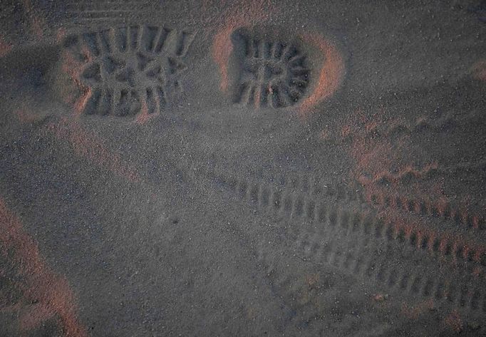 Footprint and bike tracks are seen in the dust at sunrise during the Burning Man 2012 "Fertility 2.0" arts and music festival in the Black Rock Desert of Nevada, August 29, 2012. More than 60,000 people from all over the world have gathered at the sold out festival, which is celebrating its 26th year, to spend a week in the remote desert cut off from much of the outside world to experience art, music and the unique community that develops.