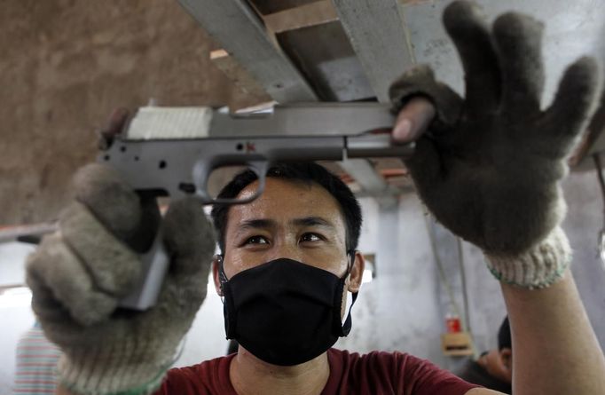 Former illegal gunsmiths work at the gun assembly line of Shooters Arms, a gun manufacturing company exporting different kinds of weapons to other countries, in Cebu city in central Philippines July 7, 2012. In the Philippines, they vote with their trigger fingers. Elections mean big business for illegal gunsmiths, who are looking forward to 2013 mid-term polls. With election-related violence commonplace, the Philippines imposes a ban on the carrying of guns for six months, from campaigning to the proclamation of winners. Picture taken July 7, 2012. To match Feature PHILIPPINES-GUNS/ REUTERS/Erik De Castro (PHILIPPINES - Tags: SOCIETY POLITICS BUSINESS CRIME LAW) Published: Čec. 29, 2012, 2:08 dop.