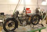 V garážích, kam byla na dobu rekonstrukce hlavní budovy přesunuta restaurátorská dílna, nyní restaurují britský motocykl Grindlay Perles.