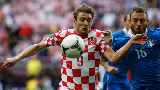 Nikica Jelavič si zpracovává míč i přes obtěžování Daniele De Rossiho během utkání Chorvatska s Itálií ve skupině C na Euru 2012.