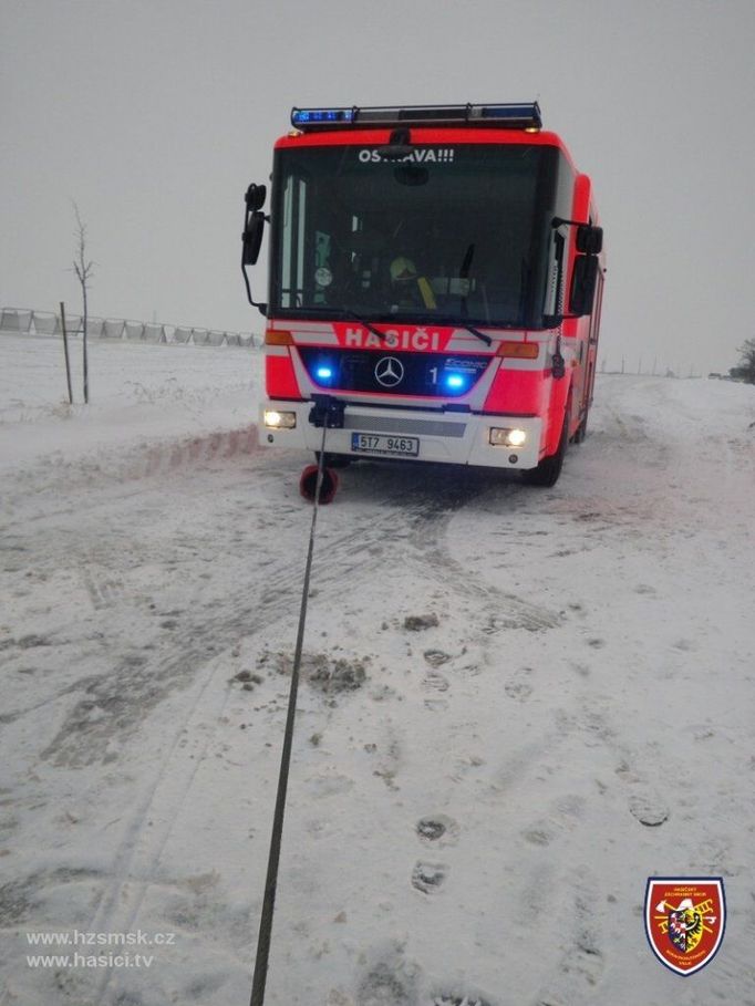 S přední částí autobusu pomohlo navijákem zásahové vozidlo CAS Mercedes Econic.