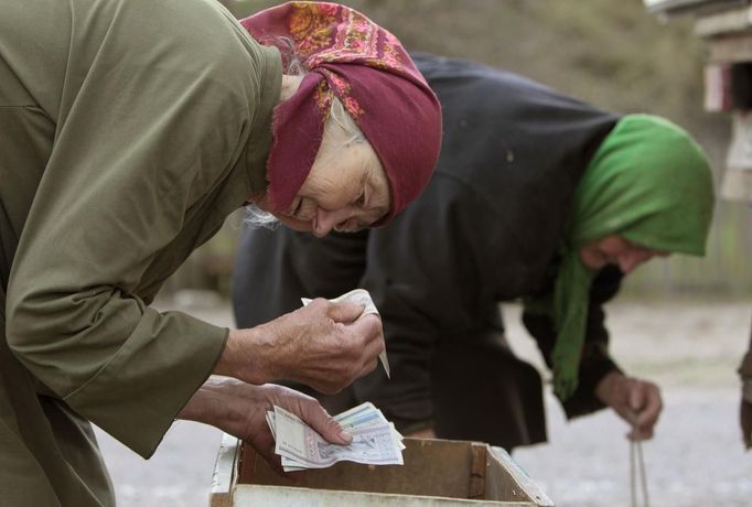 An elderly woman purchases products from a mobile shop on the eve of Radunitsa in the abandoned village of Tulgovichi