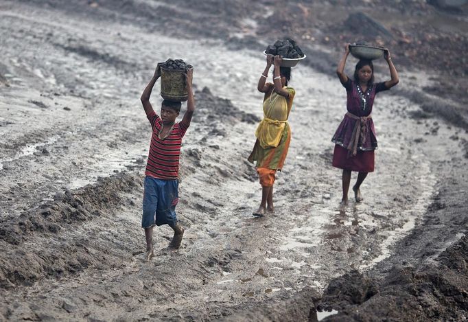 Locals carry coal from an open cast coal field at Dhanbad district in the eastern Indian state of Jharkhand September 20, 2012. With oil and gas output disappointing and hydropower at full throttle, Asia's third-largest economy still relies on coal for most of its vast energy needs. About 75 percent of India's coal demand is met by domestic production and, according to government plans, that won't change over the next five years. Picture taken September 20, 2012. To match INDIA-COAL/ REUTERS/Ahmad Masood (INDIA - Tags: BUSINESS EMPLOYMENT ENERGY SOCIETY ENVIRONMENT) Published: Říj. 21, 2012, 10:19 odp.