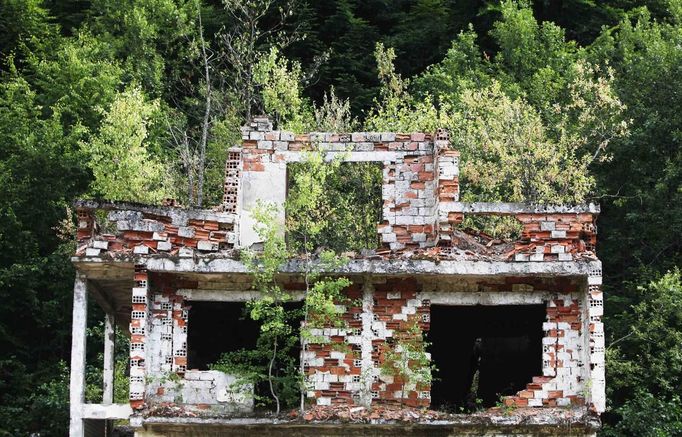 The ruins of a home are pictured in the villages near Srebrenica July 6, 2012. The ghostly town is packed with people only on the anniversary of the massacre, when families come to bury remains that are still being recovered and to commemorate the victims. But the town, which a few years ago was a jumble of burnt-out buildings and empty streets, is now slowly coming back to life. New and rebuilt houses are starting to replace the ruins of the last decade and more children are playing in the streets. However, today Srebrenica Muslims and Serbs still hold each other in deep distrust. The local government and international donors have promised millions of euros for the recovery of the town, which to the dismay of Muslims now lies in territory ceded to Bosnia's Serb Republic after the 1992-95 Bosnian War. But many Muslims are still waiting for those pledges to take hold. Picture is taken on July 6. REUTERS/Dado Ruvic (BOSNIA AND HERZEGOVINA - Tags: CONFLICT SOCIETY) Published: Čec. 8, 2012, 3:30 dop.