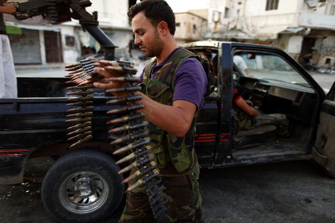 A member of the Free Syrian Army carries ammunition as he prepares for their patrol in Attarib, on the outskirts of Aleppo province July 30, 2012. REUTERS/Zohra Bensemra (SYRIA - Tags: POLITICS CONFLICT CIVIL UNREST) Published: Čec. 30, 2012, 6:57 odp.