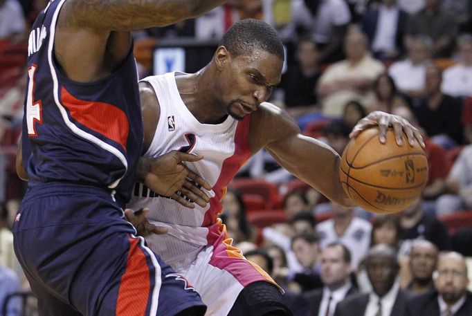 Chris Bosh se snaží prodrat ke koši přes Marvina Williamse