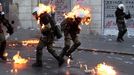 Řeckým policistů chytly uniformy od zápalné lahve, kterou na ně hodili demonstranti během střetů před budovou řeckého parlamentu na náměstí Syntagma v Aténách - 20. října 2011.