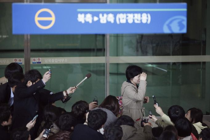 A South Korean employee (top, R) working at the Kaesong Industrial Complex (KIC), is surrounded by media upon her arrival at South Korea's CIQ (Customs, Immigration and Quarantine) office, just south of the demilitarised zone separating the two Koreas, in Paju, north of Seoul, April 3, 2013. North Korean authorities were not allowing any South Korean workers into a joint industrial park on Wednesday, South Korea's Unification Ministry and a Reuters witness said, adding to tensions between the two countries. The signboard reads "North to South, Arrival only" REUTERS/Kim Hong-Ji (SOUTH KOREA - Tags: MILITARY POLITICS BUSINESS) Published: Dub. 3, 2013, 6:31 dop.