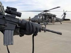 Americký voják hlídá helikoptéru na letišti v Mosulu.