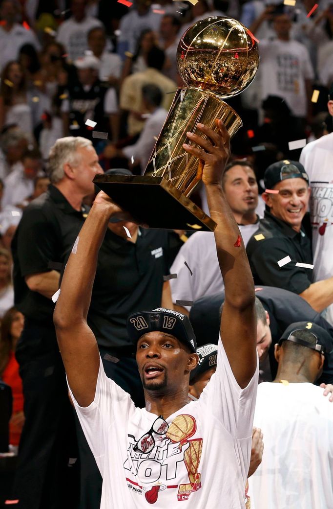 Miami Heat's Chris Bosh raises the Larry O'Brien Championship Trophy after his team defeated the San Antonio Spurs in Game 7 to take the NBA Finals basketball playoff in