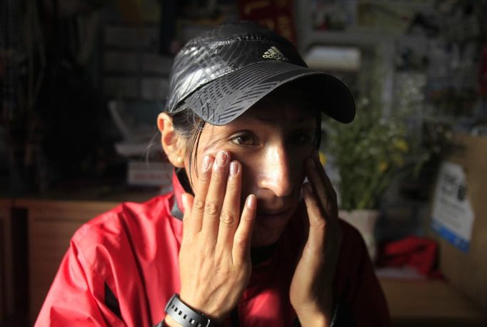 Marathon runner Gladys Tejeda, the first Peruvian athlete who qualified for the 2012 London Olympic Games, applies sunblock on her face before training at her home in the Andean province of Junin May 15, 2012. A private company will take Gladys' mother Marcelina Pucuhuaranga, 69, to London as part of the "Thank you Mom" program. For Pucuhuaranga, who received her first passport, it will be the first time travelling out of Peru. The program will take about 120 mothers of different athletes around the world to attend the games. Tejeda, the youngest of nine children, returned to her hometown to visit her mother and to focus on training where she will run more than 20 km every day in the highlands (over 4,105 meters above sea level). Picture taken May 15, 2012. REUTERS/Pilar Olivares(PERU - Tags: SPORT ATHLETICS OLYMPICS) Published: Kvě. 17, 2012, 6:58 odp.