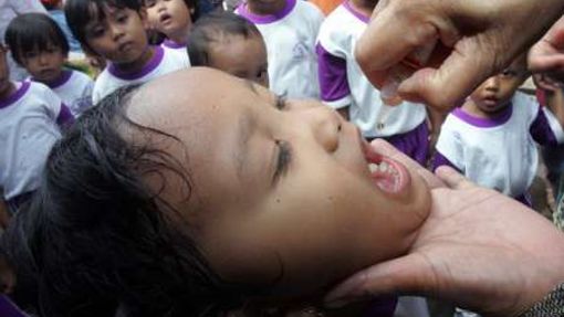 Jakarta (Indonésie) - Indoneský zdravotník očkuje dítě během masového očkování proti dětské obrně, která se konala ve středu v Indonesii.