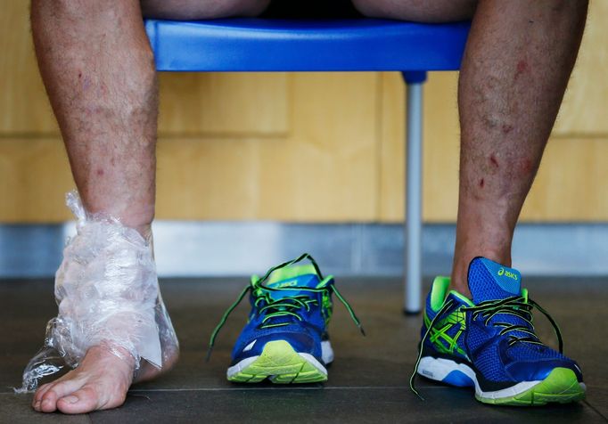 An ice bag is seen on the ankle of Japan's Luke Thompson as he speaks to members of the media after training