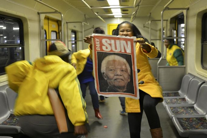 A woman holds a poster of former South African President Nelson Mandela at Johannesburg's Park Station on her way to the Memorial Service for Mandela at the First National Bank Stadium, also known as Soccer City December 10, 2013.