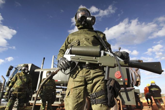 Brazilian army soldiers wearing chemical suits participate in an anti-terror simulation exercise as part of the preparation for the upcoming 2013 FIFA Confederations Cup in Brasilia. May 22, 2013. About 100 soldiers took part in the exercise which include preventive strikes against chemical, biological and radiological weapons conducted around Mane Garrincha National Stadium, according to an official statement. REUTERS/Ueslei Marcelino (BRAZIL - Tags: SPORT SOCCER MILITARY) Published: Kvě. 22, 2013, 9:29 odp.