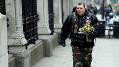 Muž nese květiny na místo útoku v Londýně.