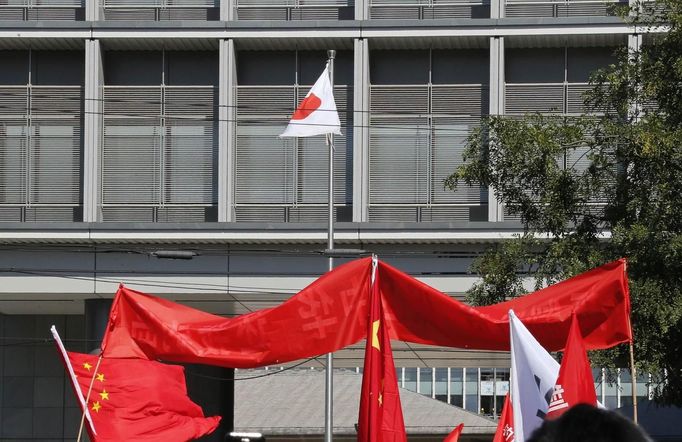 Chinese flags are seen in front of the Japanese embassy during a protest in Beijing September 15, 2012. Thousands of protesters besieged the Japanese embassy in Beijing on Saturday, hurling rocks and bottles at the building as police struggled to keep control, amid growing tensions between Asia's two biggest economies over a group of disputed islands. REUTERS/David Gray(CHINA - Tags: CIVIL UNREST POLITICS)