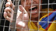 Tibetská protestující křičí po zatčení z policejní dodávky.