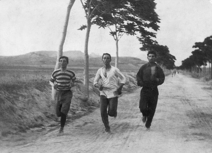 Fotografie skupinky marathónských běžců během závodu na olympijských hrách. Uprostřed je Řek Harilaos Vassilakos, který později doběhl do cíle maratónu jako druhý za již zmiňovaným Spiridonem Luisem.