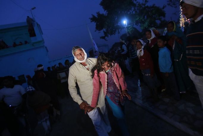 A relative of a devotee who is believed to be possessed by evil spirits holds her as she runs in a state of trance around the courtyard of Guru Deoji Maharaj temple during a ghost fair at Malajpur village in Betul district in the central Indian state of Madhya Pradesh January 26, 2013. People from across India come to this fair to be exorcised of �evil spirits�. They are usually brought by relatives and they are most often women. The exorcism involves running around the temple courtyard to make the 'ghost' weak then being beaten by a priest with a broom. Picture taken January 26, 2013. REUTERS/Danish Siddiqui (INDIA - Tags: SOCIETY RELIGION) ATTENTION EDITORS: PICTURE 15 OF 24 FOR PACKAGE 'INDIAN GHOSTBUSTERS' SEARCH 'INDIA GHOST' FOR ALL IMAGES Published: Úno. 5, 2013, 5:09 dop.