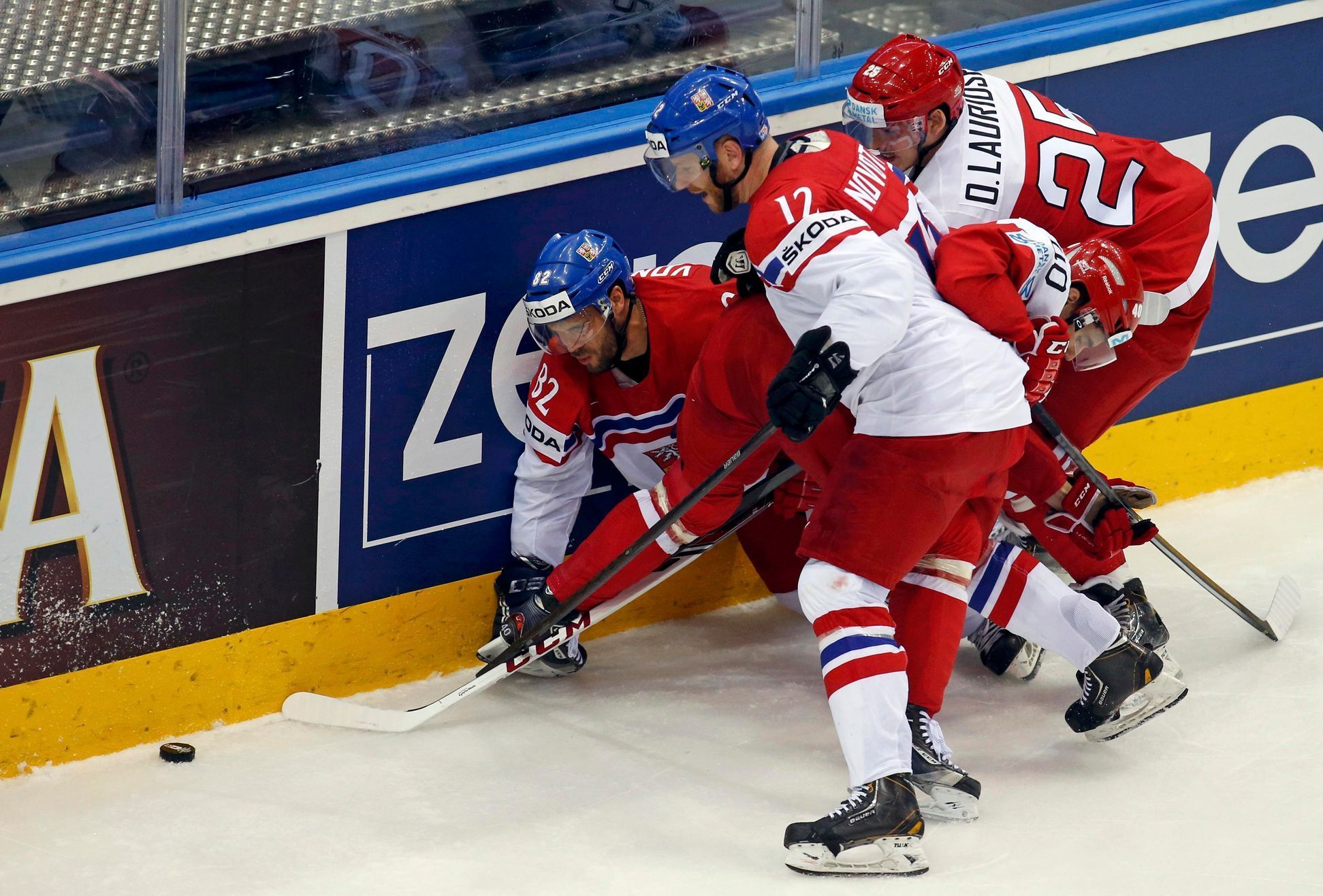 Vondrka and Novotny of the Czech Republic battle for the puck with Denmark's Lauridsen Jesper Jensen during the second period of their men's ice hockey World Championship Group A game at Chizhovka Are