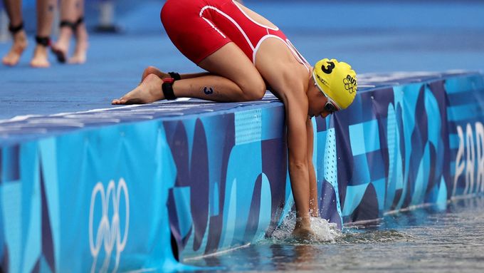 Rakušanka Lisa Perterer si oplachuje ruce v Seině před startem části triatlonového závodu.