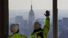 The Empire State Building stands behind workers as they clean the windows of the 100th floor observation deck in One World Trade Center before a press conference in New York, April 2, 2013. Port Authority officials unveiled Tuesday the stunning view from the top of One World Trade Center, a 360-degree eagle�s eye panorama that will instantly become one of the city�s premiere tourist attractions when it is completed in 2015. REUTERS/Lucas Jackson (UNITED STATES - Tags: CITYSPACE BUSINESS CONSTRUCTION) Published: Dub. 2, 2013, 4:37 odp.