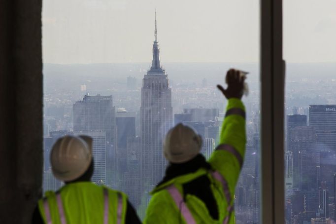 The Empire State Building stands behind workers as they clean the windows of the 100th floor observation deck in One World Trade Center before a press conference in New York, April 2, 2013. Port Authority officials unveiled Tuesday the stunning view from the top of One World Trade Center, a 360-degree eagle�s eye panorama that will instantly become one of the city�s premiere tourist attractions when it is completed in 2015. REUTERS/Lucas Jackson (UNITED STATES - Tags: CITYSPACE BUSINESS CONSTRUCTION) Published: Dub. 2, 2013, 4:37 odp.