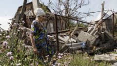 Ukrajinka před svým zničeným domem.