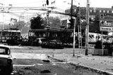 Ohořelé zbytky aut a tramvají stojí na křižovatce v centru Sarajeva po zásahu dělostřeleckou palbou. Květen 1992.