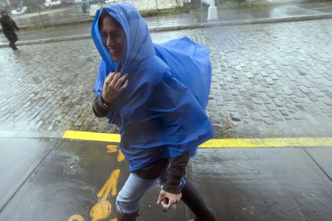 A woman shields herself from the wind as she makes her way through the Dumbo neighborhood of Brooklyn in New York, October 29, 2012. Hurricane Sandy began battering the U.S. East Coast on Monday with fierce winds and driving rain, as the monster storm shut down transportation, shuttered businesses and sent thousands scrambling for higher ground hours before the worst was due to strike. REUTERS/Keith Bedford (UNITED STATES - Tags: DISASTER ENVIRONMENT) Published: Říj. 29, 2012, 10:10 odp.